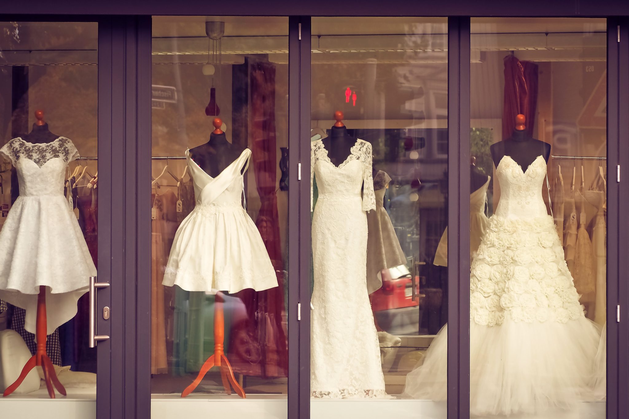 Wedding dresses displayed in a shop window.